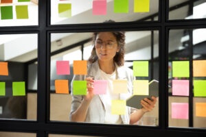 Looking through a window at a woman who has stuck post it notes on the window