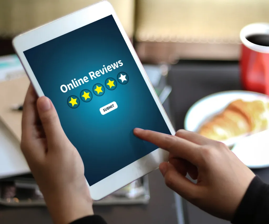 image of someone holding a tablet that says customer reviews and has four yellow stars